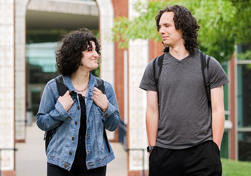 Two students walking across campus